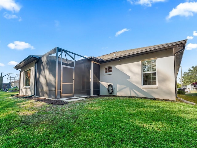 back of property featuring a lawn and a lanai