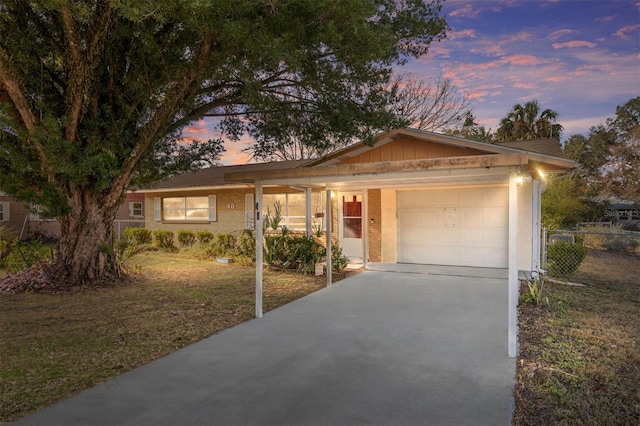 ranch-style home featuring a lawn and a garage