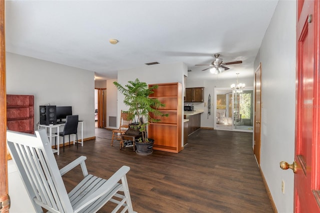 interior space featuring ceiling fan with notable chandelier and dark hardwood / wood-style flooring