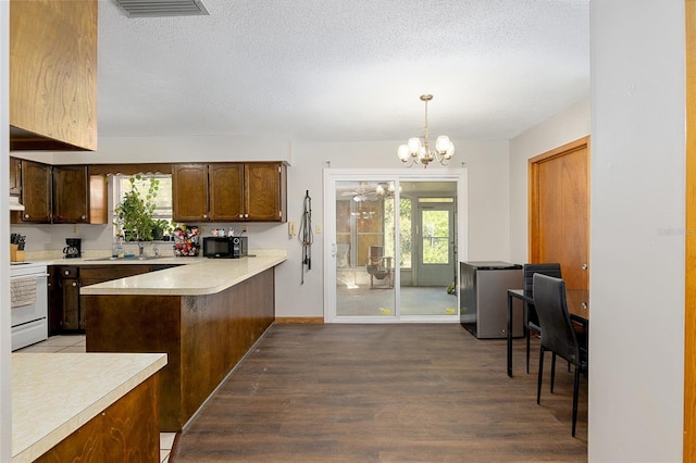 kitchen with decorative light fixtures, white range oven, dark wood-type flooring, and a wealth of natural light