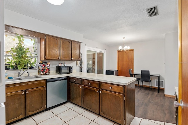 kitchen with kitchen peninsula, stainless steel dishwasher, sink, a chandelier, and hanging light fixtures