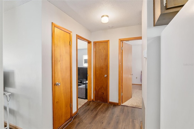 hallway featuring dark hardwood / wood-style flooring and a textured ceiling