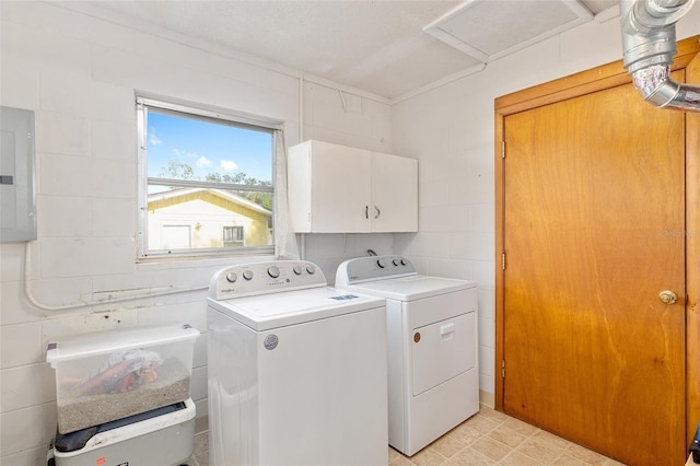 laundry area featuring cabinets, electric panel, a textured ceiling, washer and dryer, and tile walls