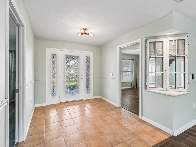 foyer featuring plenty of natural light, a textured ceiling, and light hardwood / wood-style flooring