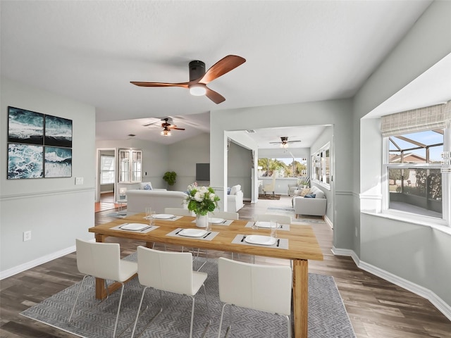 dining room with ceiling fan, lofted ceiling, and dark wood-type flooring