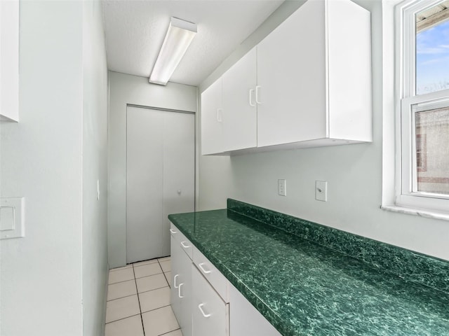 kitchen with white cabinetry and light tile patterned floors