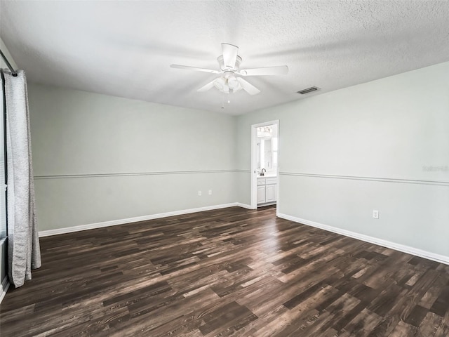 unfurnished room with ceiling fan, dark wood-type flooring, and a textured ceiling