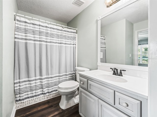 bathroom with vanity, wood-type flooring, a textured ceiling, and toilet