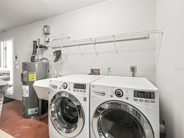 laundry room with a textured ceiling, electric water heater, and washing machine and clothes dryer