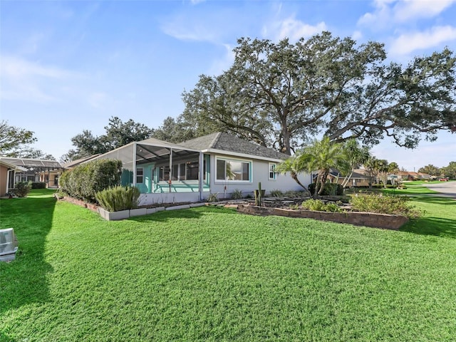 rear view of house with a lanai and a lawn