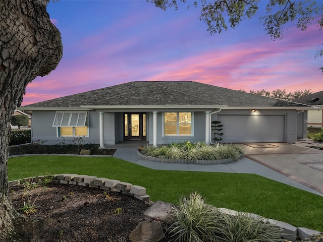 single story home with a garage and a yard