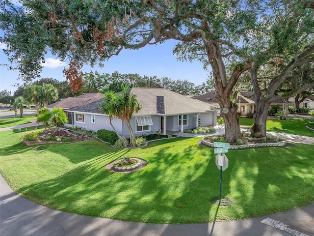 ranch-style home featuring an attached garage, a front yard, and stucco siding
