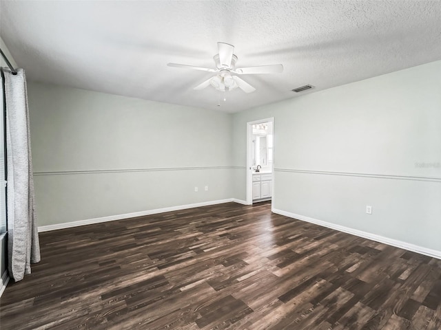 unfurnished room with ceiling fan, dark wood-type flooring, a textured ceiling, visible vents, and baseboards