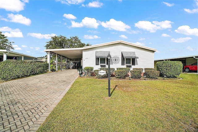 manufactured / mobile home with a front yard and a carport