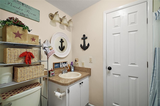 bathroom with vanity, a textured ceiling, and toilet