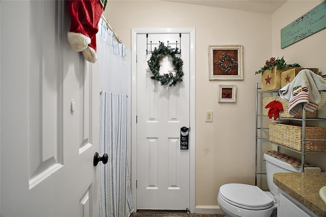 bathroom featuring vanity, toilet, and vaulted ceiling