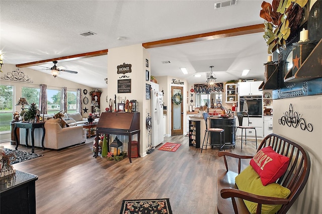 living room with dark hardwood / wood-style flooring, lofted ceiling with beams, a textured ceiling, and ceiling fan