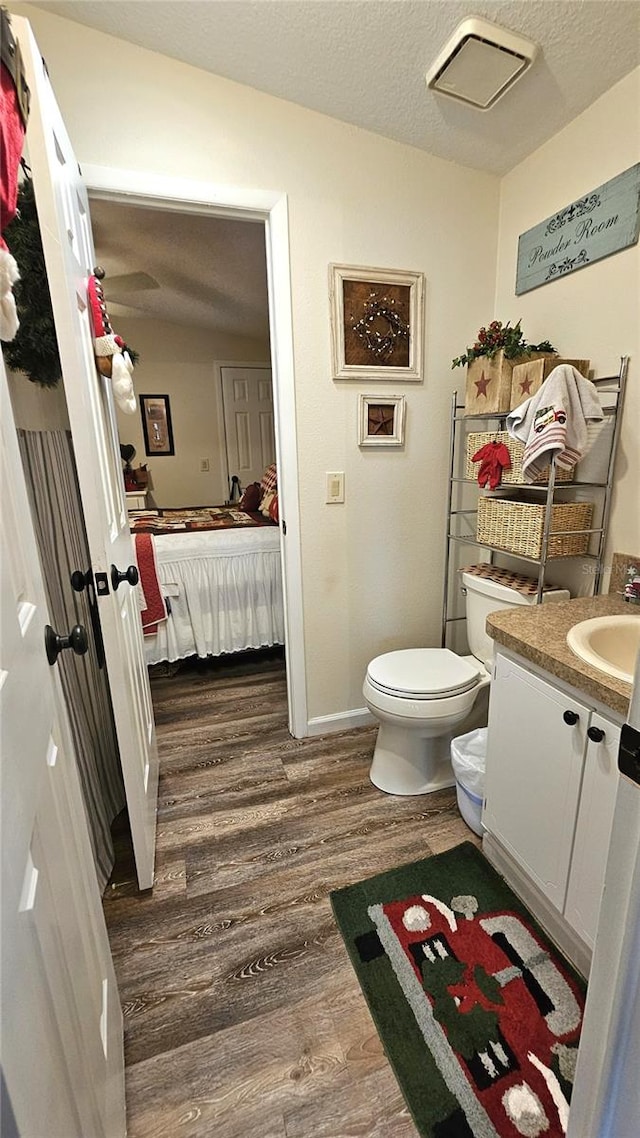 bathroom featuring hardwood / wood-style floors, vanity, a textured ceiling, and toilet