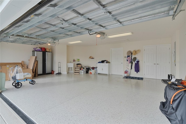 garage featuring stainless steel fridge and a garage door opener