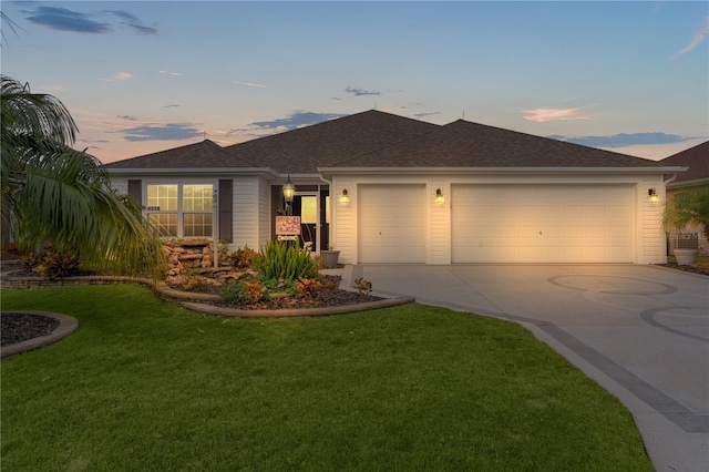 ranch-style house with a yard and a garage