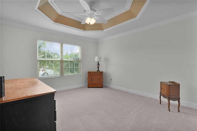 interior space featuring a tray ceiling, light carpet, ceiling fan, and ornamental molding