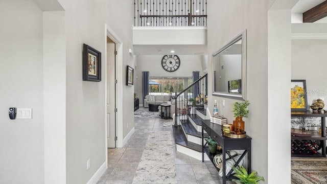 hallway featuring light tile patterned flooring and a high ceiling