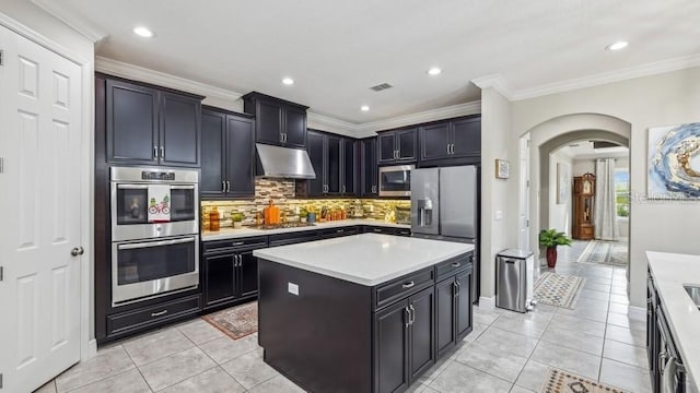 kitchen with tasteful backsplash, crown molding, a center island, and appliances with stainless steel finishes