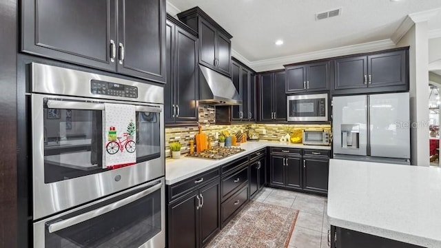 kitchen with decorative backsplash, stainless steel appliances, ornamental molding, and light tile patterned flooring