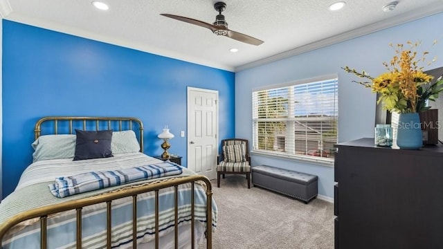 carpeted bedroom featuring ceiling fan, ornamental molding, and a textured ceiling