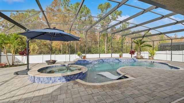 view of pool featuring an in ground hot tub, pool water feature, a patio, and glass enclosure