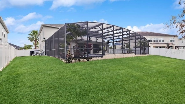 rear view of house with a lawn and glass enclosure