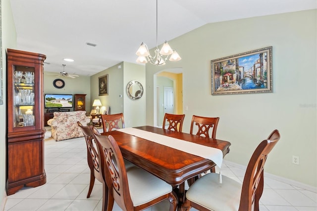 dining area featuring ceiling fan with notable chandelier, light tile patterned flooring, and lofted ceiling