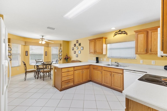 kitchen with white appliances, sink, ceiling fan, light tile patterned floors, and kitchen peninsula