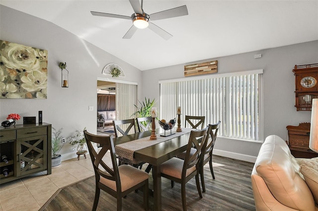 dining area with ceiling fan, wood-type flooring, and vaulted ceiling