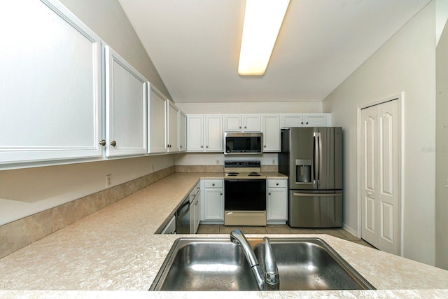 kitchen featuring white cabinetry, sink, appliances with stainless steel finishes, and vaulted ceiling