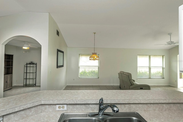 kitchen with a wealth of natural light, sink, pendant lighting, and lofted ceiling