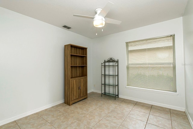 tiled spare room with ceiling fan