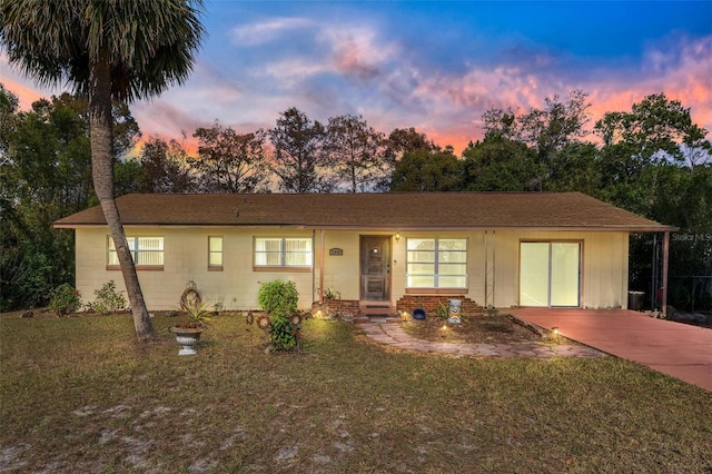 single story home featuring a carport and a lawn