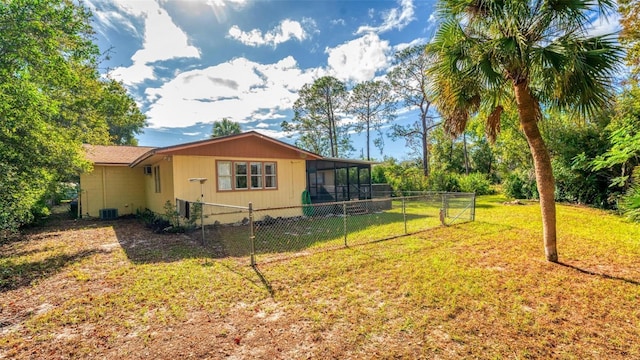 view of side of property with a lawn, central air condition unit, and a sunroom