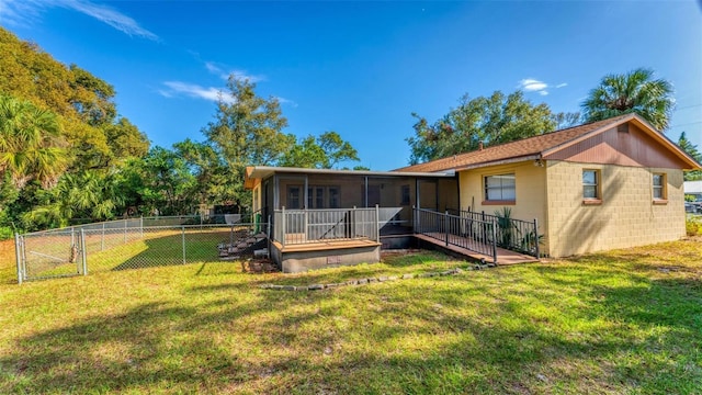 rear view of property featuring a yard and a sunroom