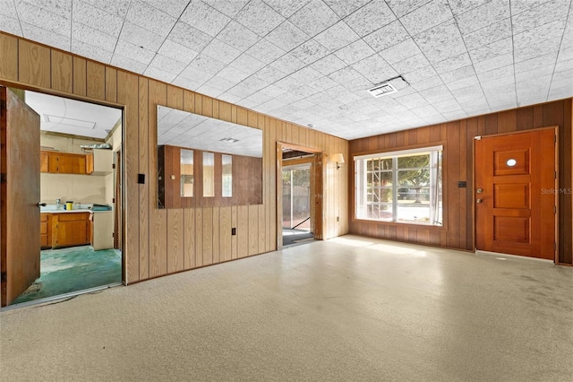 unfurnished living room with wood walls