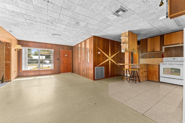 kitchen featuring wooden walls and stove