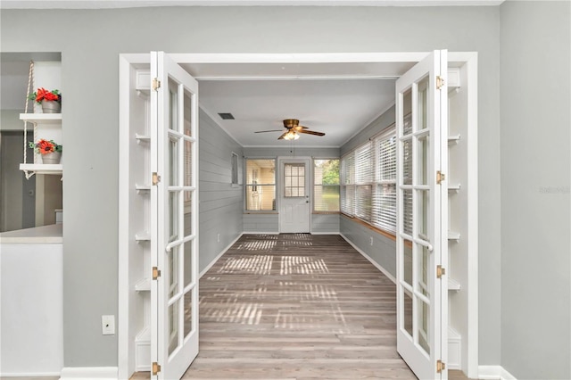 unfurnished sunroom with ceiling fan and french doors