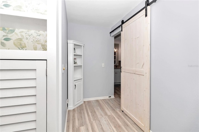 corridor featuring light hardwood / wood-style flooring and a barn door