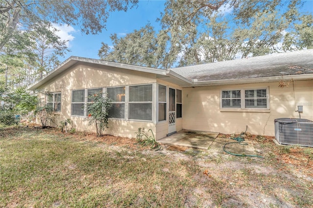 rear view of property featuring central AC, a yard, and a patio