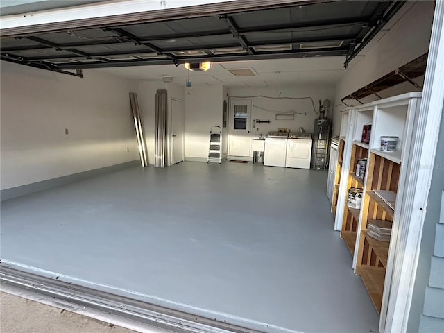 garage featuring water heater and washer and dryer