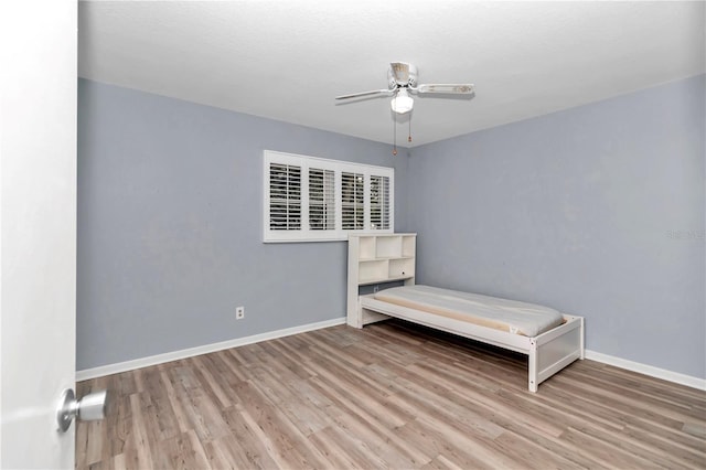 unfurnished bedroom with ceiling fan and wood-type flooring