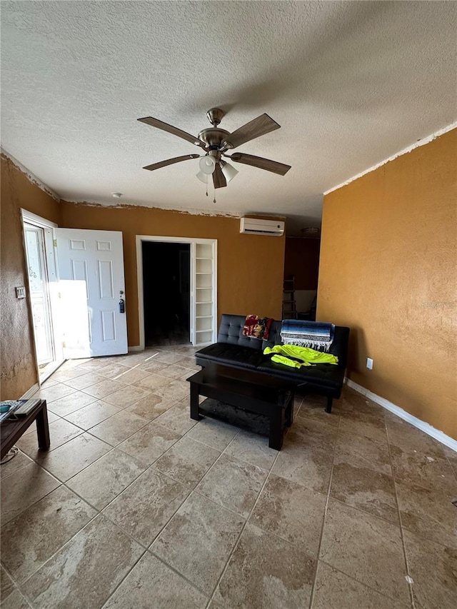 interior space featuring a textured ceiling, ceiling fan, and a wall mounted air conditioner