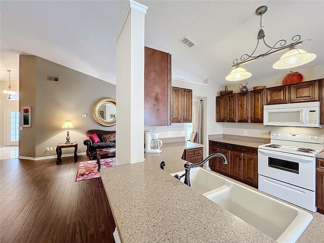 kitchen featuring a textured ceiling, white appliances, dark wood-type flooring, and hanging light fixtures