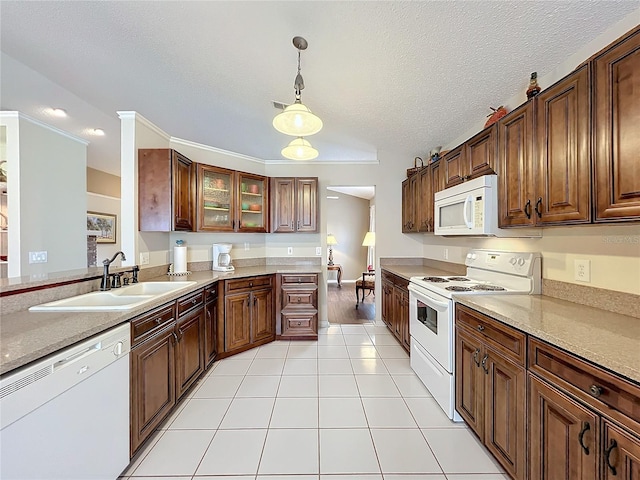 kitchen with a textured ceiling, white appliances, sink, light tile patterned floors, and decorative light fixtures